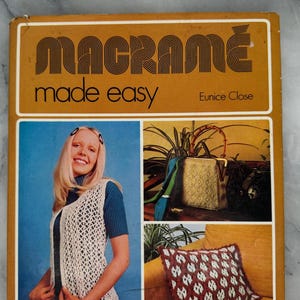 May include: Vintage book cover with the title "MACRAMÉ made easy" in orange and white. The cover features a woman wearing a white macrame vest, a gold handbag, and a decorative pillow. The background is a mix of blue and orange.