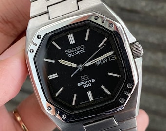 Raro reloj Seiko SQ Sports Oak Quartz 8229-503A con esfera negra, fecha y día para hombre, vintage de 1982.