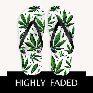 May include: A pair of flip-flops featuring a white base with a repeating green cannabis leaf pattern and black straps. Below the footwear, a black rectangular graphic contains the white text HIGHLY FADED in a clean, sans-serif font.