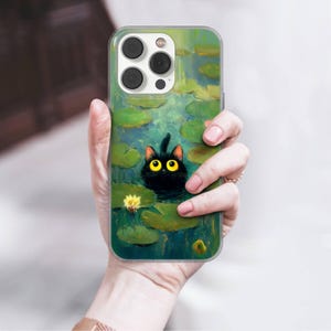 May include: A clear phone case featuring a whimsical illustration of a black cat in a pond with lily pads and a yellow flower. The artwork has a painterly style with green and blue hues.