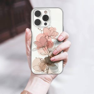 May include: Clear phone case featuring a floral design. The case has a delicate illustration of flowers in shades of pink and brown, with black line art. The design is set against a white background with soft, circular shapes.