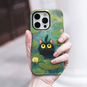 May include: A green phone case featuring a black cat with yellow eyes in a pond of lily pads. The case has a black border and a glossy finish. The artwork has a painterly style with green, blue, and yellow hues.