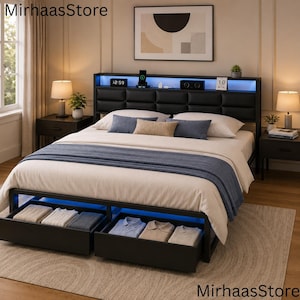 May include: A black metal bed frame with a tufted headboard featuring integrated blue LED lighting and a storage shelf. The bed includes two pull-out drawers at the base containing folded clothing, topped with a white comforter and blue throw.