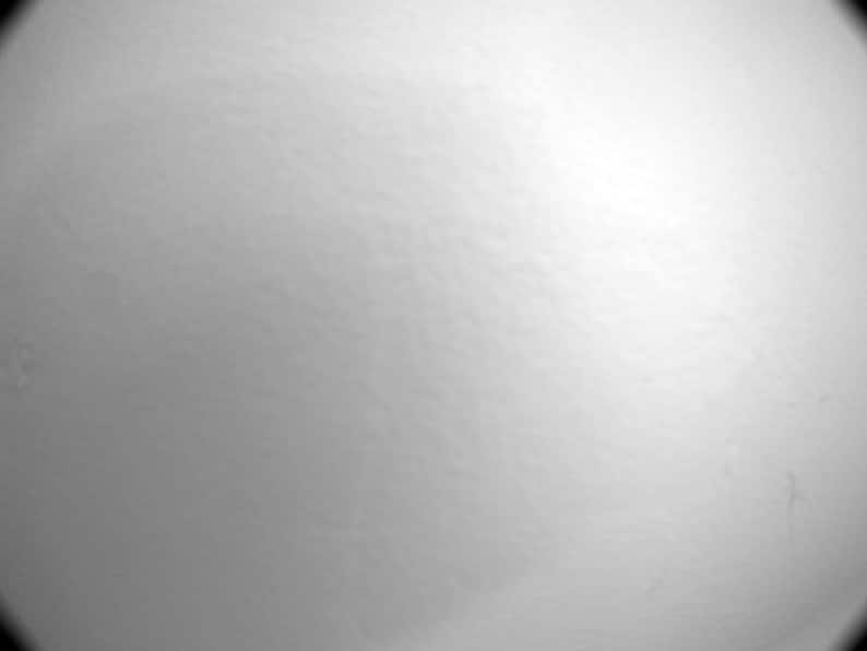 May include: A smooth, solid white surface with a subtle matte texture. The lighting creates a soft gradient effect, transitioning from a brighter, illuminated area on the right side to a slightly darker, shadowed tone on the left side of the frame.