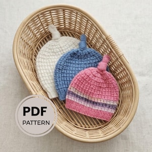 Puede incluir: Tres gorros tejidos con nudos en la parte superior en blanco, azul y un patrón de rayas rosas. Los gorros presentan un punto de rejilla texturizado y un borde acanalado. Un círculo en la esquina inferior izquierda contiene el texto PDF PATTERN.