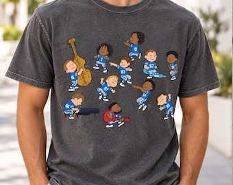 May include: A charcoal gray crew neck t-shirt featuring a graphic print of cartoon characters wearing blue football jerseys with various numbers. The characters are depicted playing musical instruments including a double bass, piano, and red electric guitar.