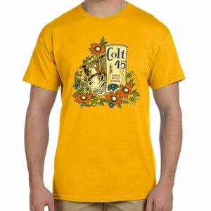 May include: Mustard yellow t-shirt with a cartoon horse head, smiling, surrounded by flowers. The shirt displays the text "Colt 45" and "Stout Malt Liquor".