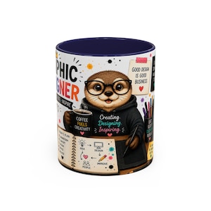 Op de afbeelding: Een witte keramische mok met een donkerblauwe binnenkant, voorzien van een cartoonotter met een bril en een zwarte hoodie. Het ontwerp bevat teksten zoals "Graphic Designer", "Good design is good business" en "Coffee fuels creativity", naast illustraties van een notitieboek, pennen en een tekentablet.