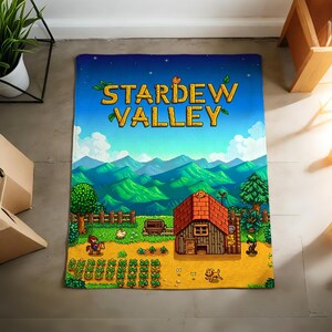 Pu&ograve; includere: Tappeto rettangolare a tema Stardew Valley. Presenta un paesaggio vibrante con una casa, colture e il titolo del gioco. Il design include un cielo blu, montagne verdi e una scena dettagliata della fattoria.