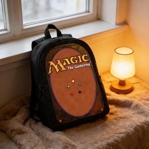 May include: Black backpack with the Magic: The Gathering card back design. The backpack has a top handle and adjustable shoulder straps. The Magic: The Gathering logo is in gold, and the card back is brown with coloured dots.