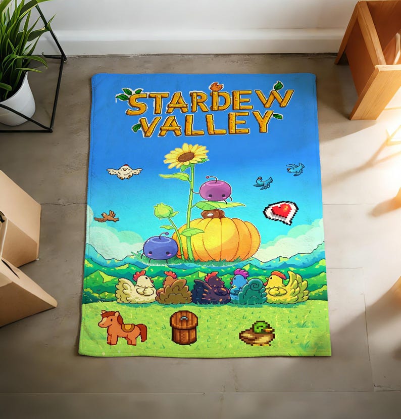 Pu&ograve; includere: Un tappeto rettangolare blu e verde a tema Stardew Valley. Il tappeto presenta grafiche pixelate di un girasole, una zucca e vari animali da fattoria. Le parole "STARDEW VALLEY" sono in alto in giallo e verde.
