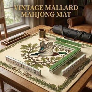 May include: A vintage Mahjong mat with a mallard duck illustration. The mat is beige with green and brown accents, and the text "VINTAGE MALLARD MAHJONG MAT" is displayed at the top. Mahjong tiles and accessories are arranged on a wooden table.