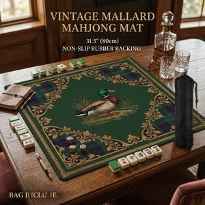 Puede incluir: Un tapete de Mahjong verde con una ilustración de pato real, que mide 80cm. El tapete tiene un borde a cuadros y detalles dorados. Se muestra el texto "VINTAGE MALLARD MAHJONG MAT". Incluye una bolsa de transporte negra.