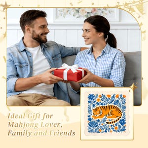 May include: A red gift box with a white ribbon is being exchanged between two people. The image also includes a framed illustration of a tiger surrounded by blue flowers and foliage. The text on the image says "Ideal Gift for Mahjong Lover, Family and Friends."