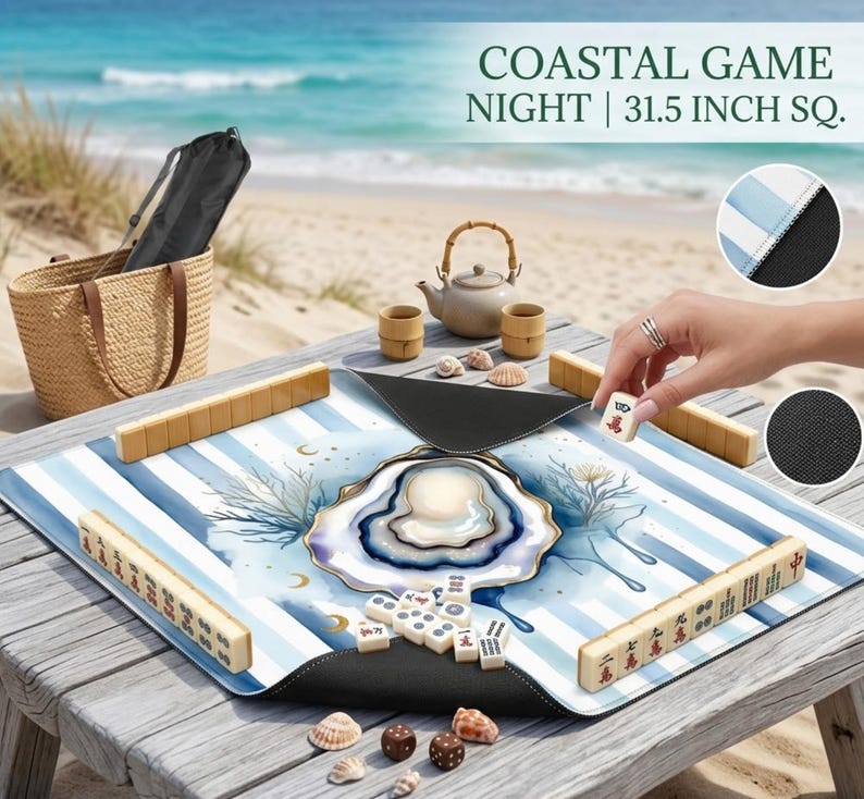 May include: A Mahjong game set with a coastal theme, set on a wooden table. The 80 cm square game board has blue and white stripes and an oyster design. Accessories include wooden tiles, a teapot, cups, and seashells. The text "COASTAL GAME NIGHT" is visible.