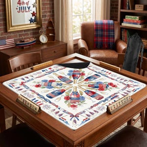 K&ouml;nnte beinhalten: Ein Spieltisch aus Holz mit einer dekorativen Matte mit einem patriotischen Design aus Champagnerflaschen, Feuerwerk und floralen Elementen in Rot, Wei&szlig; und Blau. Der Tisch ist von St&uuml;hlen und anderen dekorativen Gegenst&auml;nden umgeben.