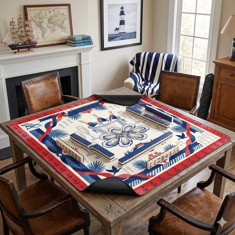 May include: A wooden table with a nautical-themed game mat featuring a red, white, and blue design. The mat has a border of red anchors and includes images of champagne bottles, oysters, and game pieces. The table is surrounded by leather chairs.