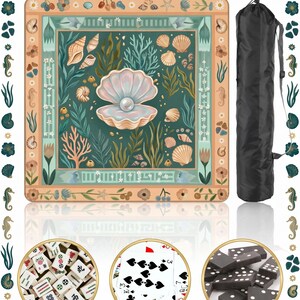 Puede incluir: Una alfombra de juego cuadrada y decorativa con un dise&ntilde;o tem&aacute;tico marino, con conchas marinas, coral y una perla en una ostra abierta. La alfombra va acompa&ntilde;ada de una funda de transporte negra. La imagen tambi&eacute;n muestra fichas de Mahjong, cartas de p&oacute;quer y domin&oacute;.