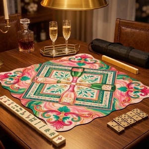 Peut inclure: Une table en bois avec un tapis décoratif coloré représentant des bouteilles et des verres de champagne. Des flûtes à champagne et une carafe sont visibles. Des tuiles de mahjong et des dominos sont également sur la table.