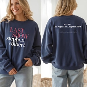 May include: Navy blue sweatshirt with the text "LAST SHOW with stephen colbert" in pink and white on the front. The back of the sweatshirt has the text "05.21.2026 The Night The Laughter Died" in white.