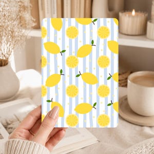 May include: A rectangular card featuring a lemon pattern. The design includes yellow lemons and lemon slices on a background of blue and white vertical stripes. Small yellow dots are scattered throughout the design.