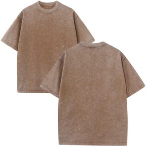 two identical light brown t-shirts, one facing the camera and the other facing away.
