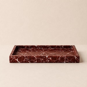 May include: A rectangular tray featuring a deep red base color with intricate white veining throughout the surface. The tray has a smooth, polished finish and raised edges, creating a shallow basin for holding various small items.