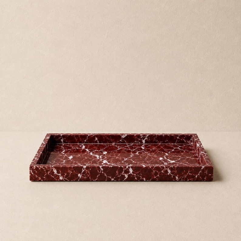 May include: A rectangular tray featuring a deep burgundy red base color with prominent white veining throughout the surface. The tray has a smooth, polished finish and raised edges, creating a structured, open container for various small items.