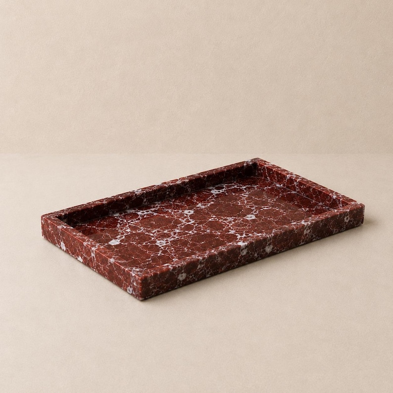 May include: A rectangular tray crafted from deep red stone with prominent white veining throughout the surface. The tray features a flat base and raised edges, showcasing a polished finish that highlights the natural patterns of the material.