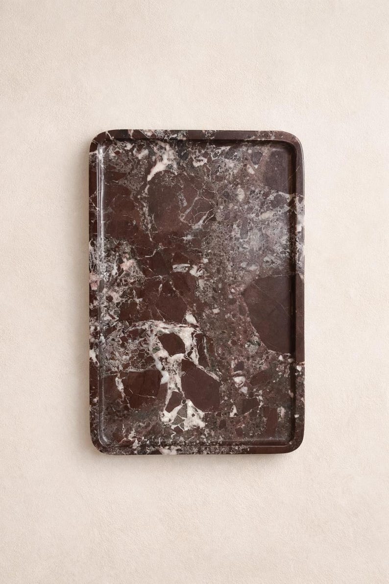 May include: Rectangular serving tray with a rich, dark burgundy marble pattern. The tray features rounded corners and a polished finish, showcasing a blend of burgundy, white, and grey veining. Ideal for serving or decorative display.