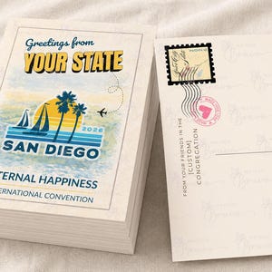 Op de afbeelding: Een stapel ansichtkaarten met een vintage ontwerp. De voorkant van de ansichtkaart toont de tekst "Greetings from YOUR STATE" boven een San Diego-scène met palmbomen, een zeilboot en de tekst "SAN DIEGO" en "ETERNAL HAPPINESS". De achterkant heeft een postzegel en tekst.