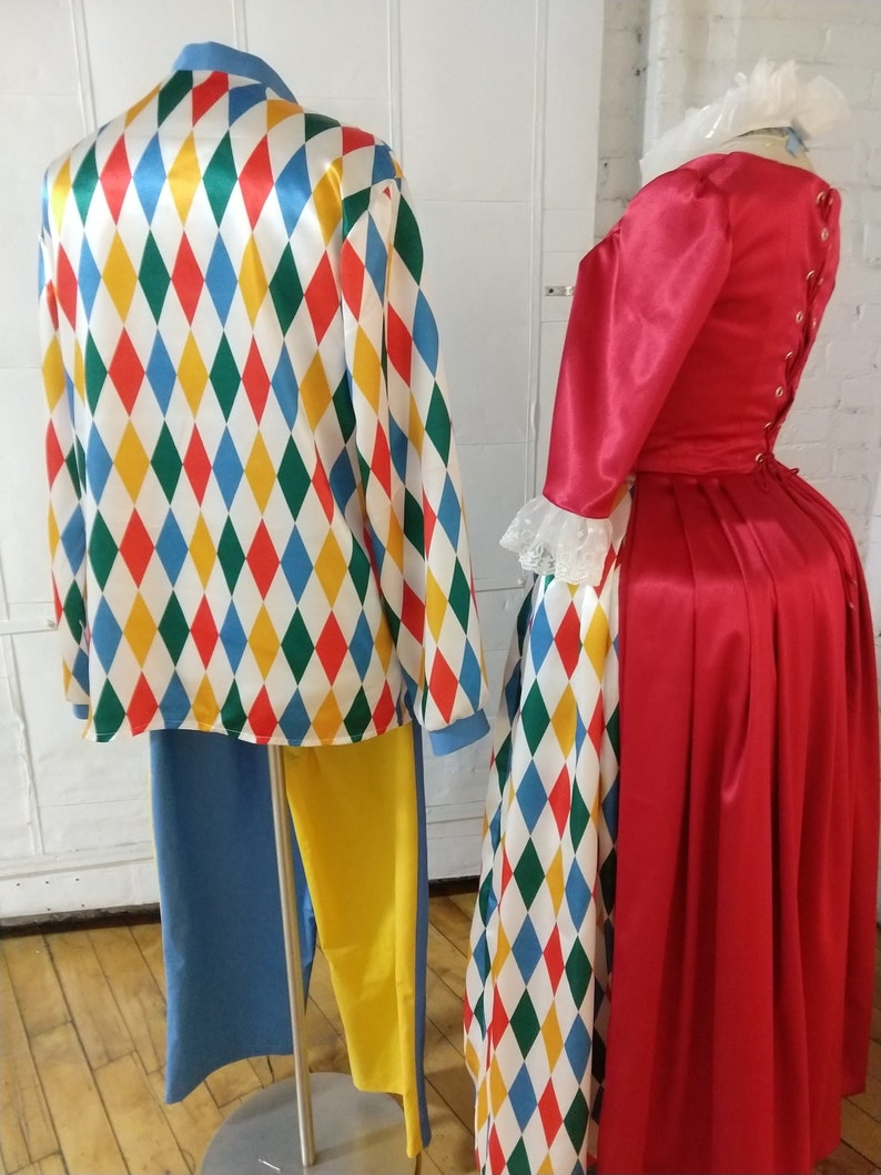 May include: A red and white harlequin patterned jacket with yellow and blue accents. The jacket is paired with blue and yellow pants. A red dress with a white lace collar and a harlequin patterned skirt.