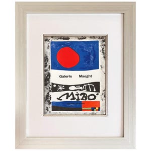 May include: Framed art print featuring a vibrant abstract design. The artwork includes a large red circle against a blue background, with the text "Galerie Maeght" above a stylized "Miro" signature. The print is encased in a white mat and a silver frame.