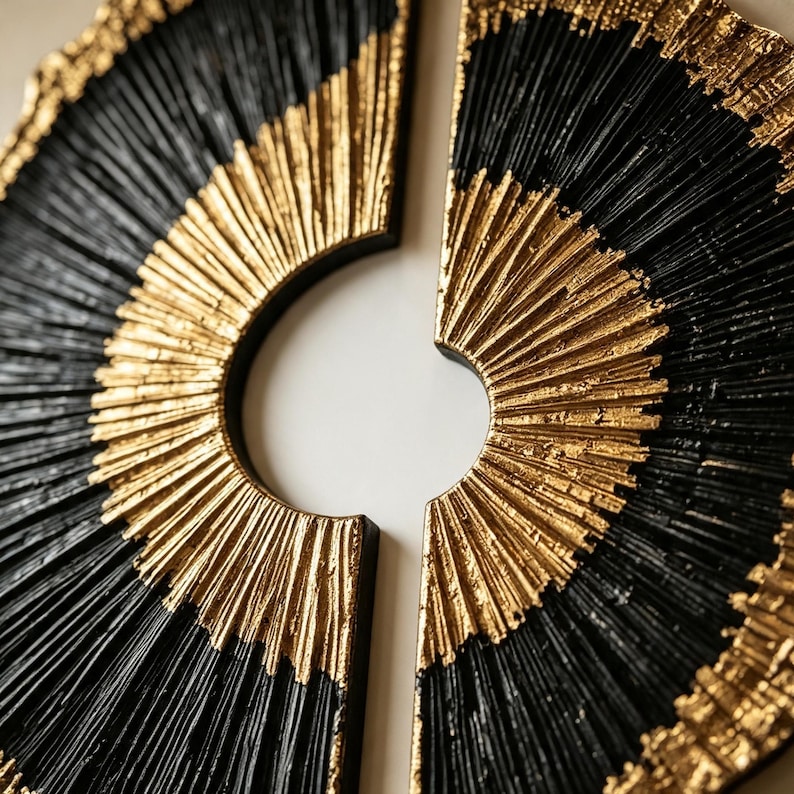 Op de afbeelding: Een cirkelvormig wandkunstobject verdeeld in twee halfronde secties, met een gestructureerd radiaal patroon. Het ontwerp wisselt af tussen diepzwarte en metallic gouden afwerkingen, met fijne, verhoogde lijnen vanuit het midden.