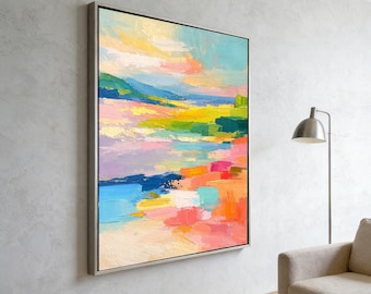 May include: A large rectangular framed wall art piece featuring an abstract landscape painting with thick, textured brushstrokes in vibrant shades of pink, yellow, blue, green, and orange, displayed in a thin metallic frame on a light grey wall.