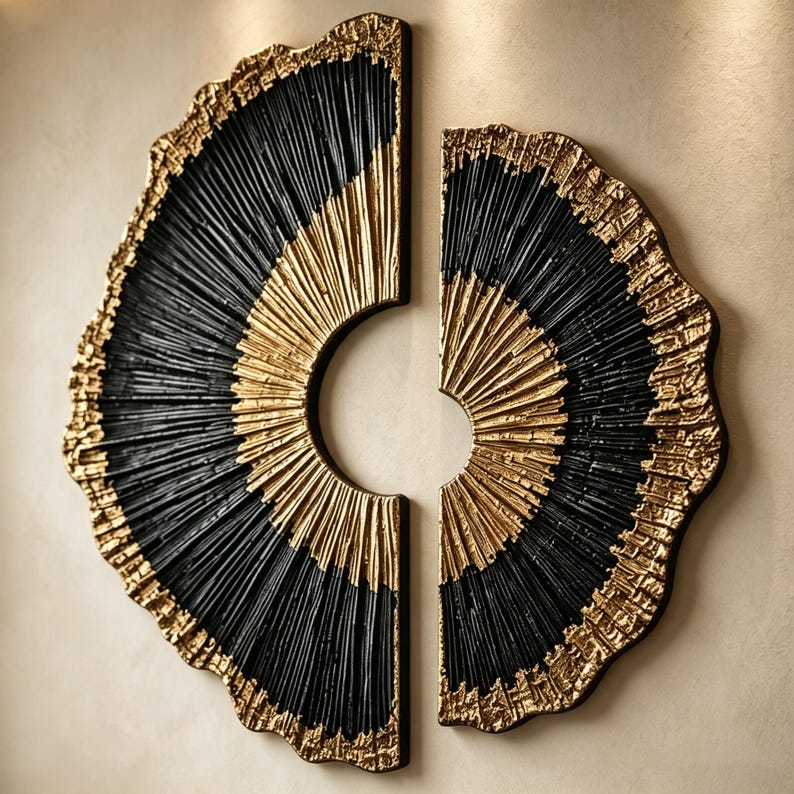 Op de afbeelding: Een tweedelige wandkunstset bestaande uit halfronde panelen met een getextureerd, radiaal patroon. Het ontwerp toont afwisselende banden van zwart en metallic goud, met een ruwe, organische afwerking aan de randen.