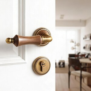 Puede incluir: Primer plano de una manija y cerradura de puerta. La manija es de madera y latón, con un diseño decorativo. La cerradura tiene un ojo de cerradura y una placa circular de latón. La puerta es blanca.