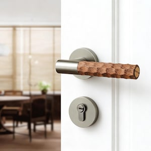 Puede incluir: Un juego de manija de puerta moderno con acabado de níquel cepillado. La manija presenta un agarre de madera marrón texturizado. El juego incluye una placa trasera redonda y una cubierta de ojo de cerradura a juego, montados en una puerta blanca.