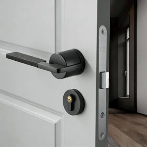 May include: Black door handle and lock set. The handle is rectangular with a textured grip. The lock and handle are black, mounted on a white door. The door frame is gray. The lock has a gold-colored keyhole.