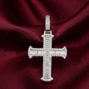 Peut inclure: Pendentif en argent en forme de croix avec un motif de diamants rectangulaires et ronds. La croix est posée sur un fond de satin rouge foncé. Le pendentif est doté d'une bélière pour une chaîne.