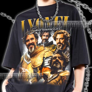 以下が含まれることがあります： 黒いTシャツ。金色の文字で「LYONEL Baratheon」と書かれた、鎧を着た男性のグラフィックが特徴です。 ヴィンテージ感のあるデザインです。 モデルは2XLサイズを着用しています。 ユニセックスのTシャツです。
