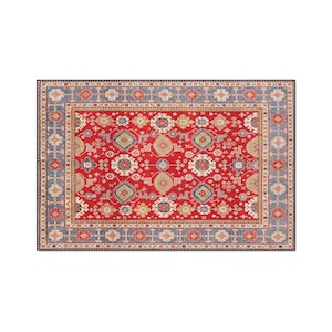 Puede incluir: Una alfombra rectangular con un diseño tradicional detallado. La alfombra presenta un campo central rojo con intrincados patrones florales y geométricos en tonos de azul, beige y dorado. Un borde azul enmarca el diseño.