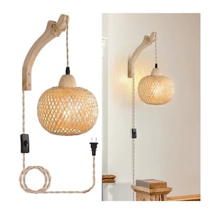 Op de afbeelding: Een wandlamp met een geweven rotan lampenkap en een houten arm. Het licht heeft een neutraal kleurenpalet met een beige snoer, een zwarte schakelaar en een standaard stekker. De armatuur is ontworpen voor gebruik binnenshuis.