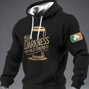 May include: Black hooded sweatshirt with a white lining and drawstring. The front has gold embroidered text saying "Hello Darkness My Old Friend" with a beer glass design. An Irish flag patch is on the sleeve.