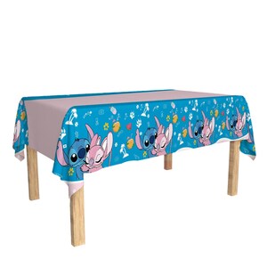May include: A rectangular tablecloth featuring a light blue border with cartoon characters and a light pink center. The border has a repeating pattern of blue and pink characters, flowers, and fruit.