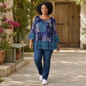 May include: A long-sleeve tunic featuring a blue and purple patchwork pattern with tiered ruffled cuffs and a tiered hem, paired with dark blue denim jeans and white sneakers. The tunic has a round neckline with a small keyhole opening.