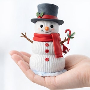 Puede incluir: Figura de muñeco de nieve festivo con sombrero de copa, bufanda roja y bastón de caramelo. El muñeco de nieve tiene nariz de zanahoria, ojos de botón y brazos de ramita. Mide aproximadamente 10 cm de altura.
