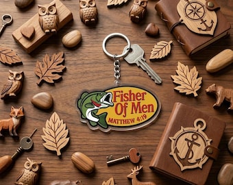 May include: A collection of wooden carvings and accessories, including owls, leaves, and animals, arranged on a wooden surface. A keychain with the text "Fisher Of Men" and a leather-bound journal with a nautical design are also present. The items are in various shades of brown.