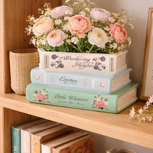 Può includere: Una tazza di ceramica bianca con manico nero e la scritta "But First, Coffee" in grassetto nero. La tazza è alta circa 10 cm e contiene circa 350 ml di liquido.