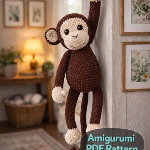 May include: A handmade brown and cream crochet monkey hanging from a hook. The amigurumi monkey has a textured body, with a cream-coloured face, hands, and feet. The image includes the text "Amigurumi PDF Pattern".